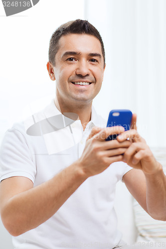 Image of happy man with smartphone at home