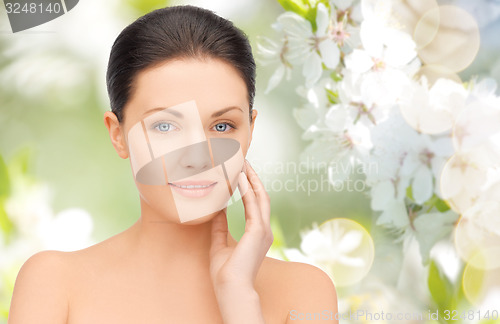 Image of beautiful young woman touching her face