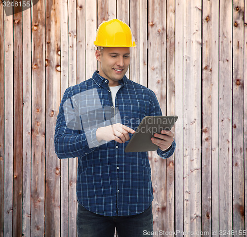 Image of smiling male builder in helmet with tablet pc