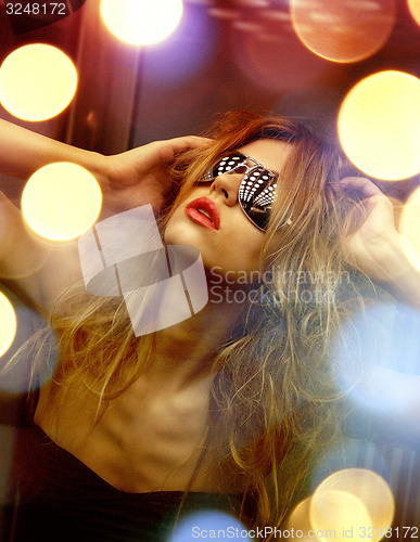 Image of beautiful woman in sunglasses in elevator