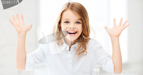 Image of surprised and laughing girl with raised hands