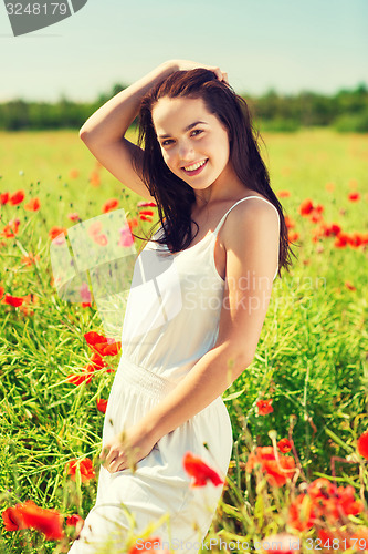 Image of smiling young woman on poppy field