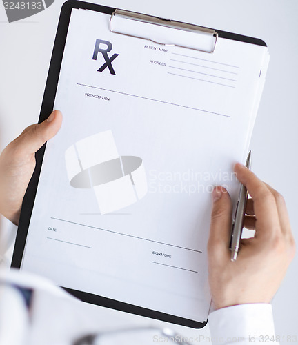 Image of male doctor writing prescription paper