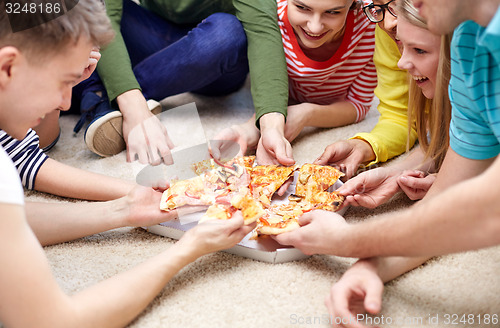 Image of close up of happy friends eating pizza at home