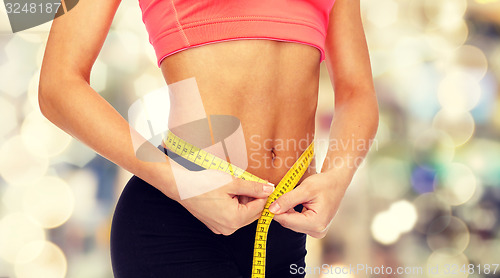 Image of close up of female hands measuring waist