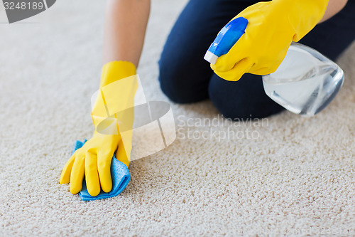 Image of close up of woman with cloth cleaning carpet