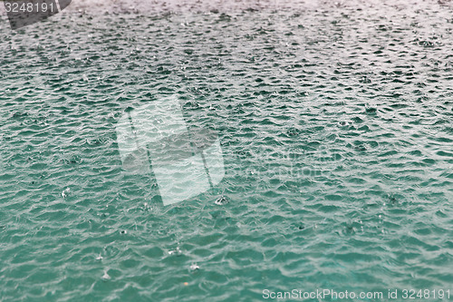 Image of water surface with raindrops at rainy day