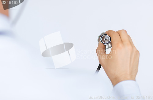 Image of doctor hand with stethoscope listening somebody