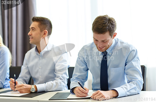 Image of group of smiling businesspeople meeting in office