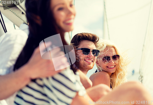 Image of smiling friends sitting on yacht deck