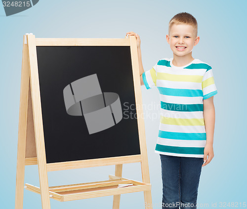 Image of happy little boy with blank blackboard