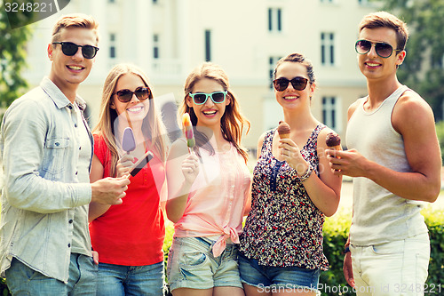 Image of group of smiling friends with ice cream outdoors