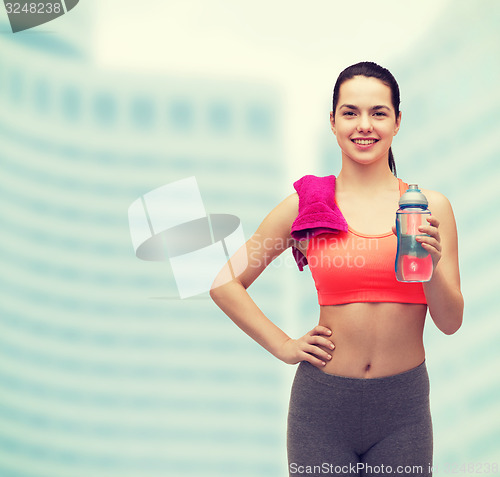 Image of sporty woman with towel and water bottle