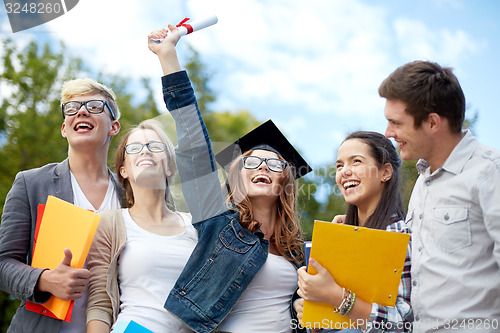 Image of group of smiling students with diploma and folders