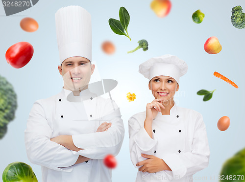 Image of happy chef couple or cooks over food background