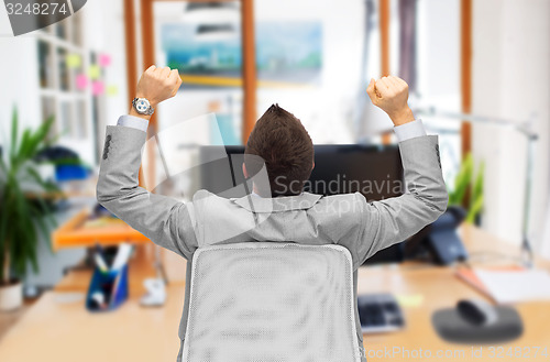 Image of businessman sitting in office chair from back