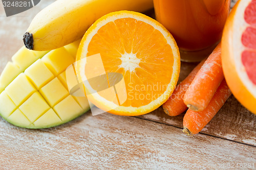 Image of close up of fresh fruits and juice glass on table