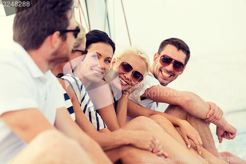 Image of smiling friends sitting on yacht deck