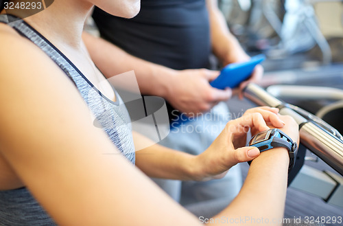 Image of close up of woman setting heart-rate watch at gym