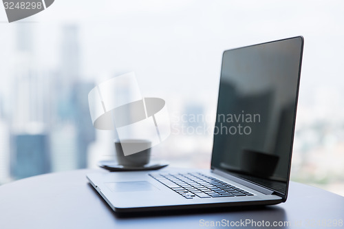 Image of close up of laptop and coffee cup on office table