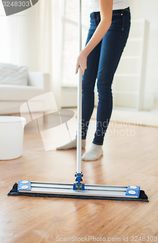 Image of close up of woman with mop cleaning floor at home