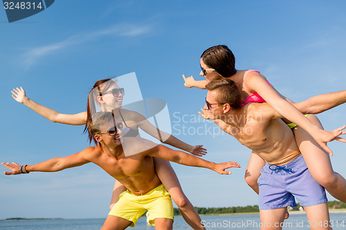 Image of smiling friends having fun on summer beach