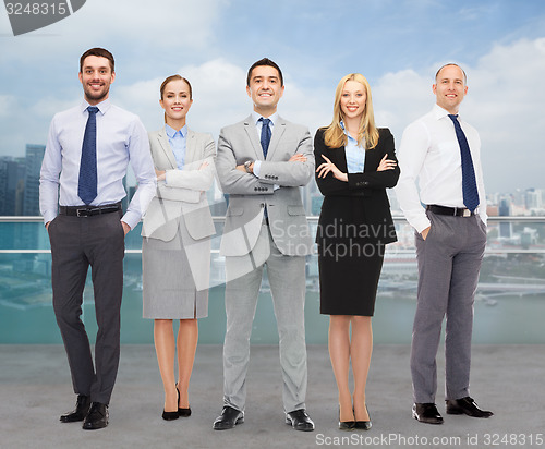 Image of group of smiling businessmen over city background