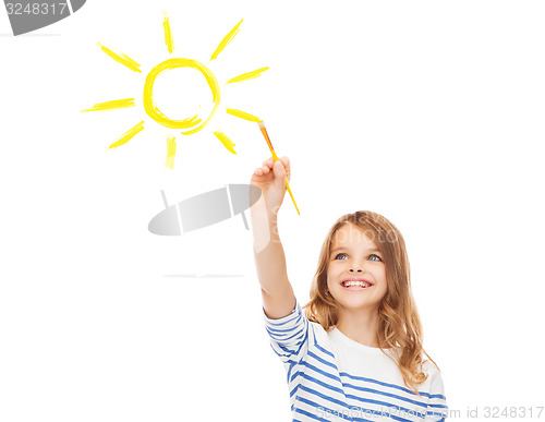 Image of cute little girl drawing sun with brush