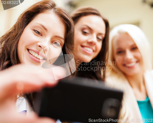 Image of beautiful girls taking selfie in the city