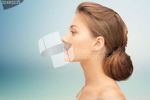 Image of beautiful young woman face over blue background