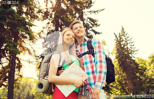 Image of smiling couple with map and backpack in nature