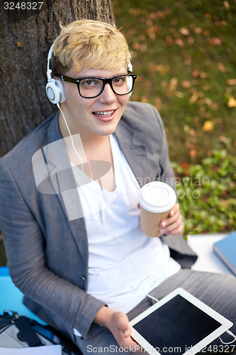 Image of happy teenage boy in headphones with tablet pc