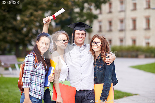 Image of happy teenage students with diploma and folders