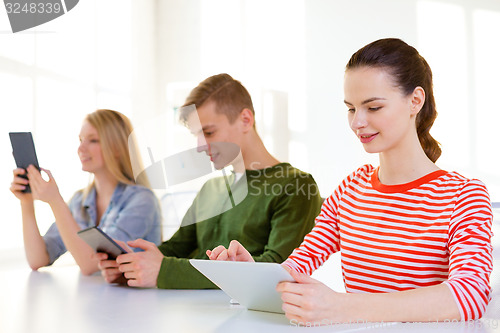 Image of smiling students with tablet pc at school