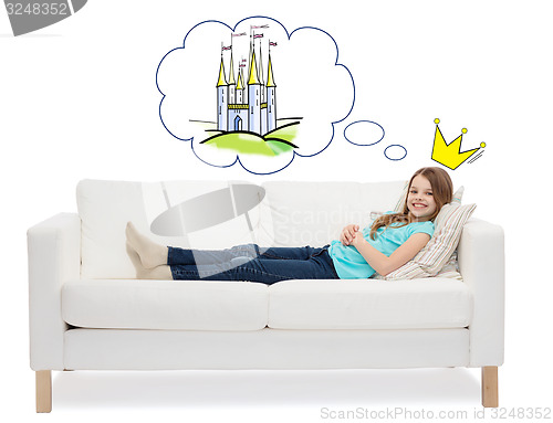 Image of smiling little girl lying on sofa and dreaming