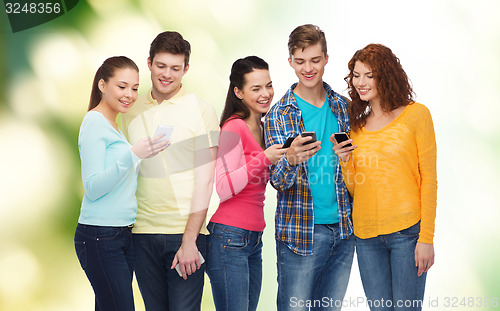 Image of group of smiling teenagers with smartphones