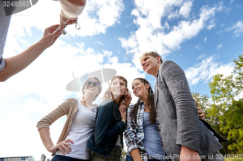 Image of group of happy friends with camera taking picture