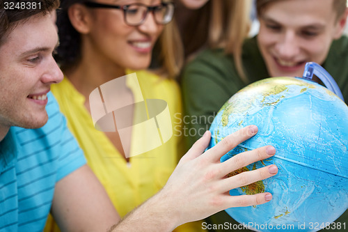 Image of group of smiling students looking at globe