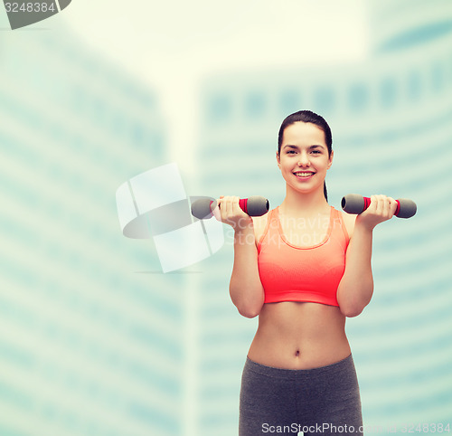 Image of young sporty woman with light dumbbells