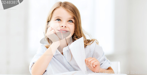 Image of little student girl studying at school