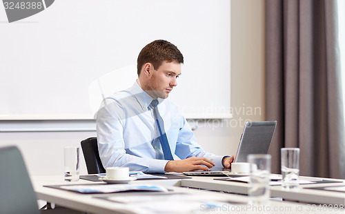 Image of businessman with laptop working in office