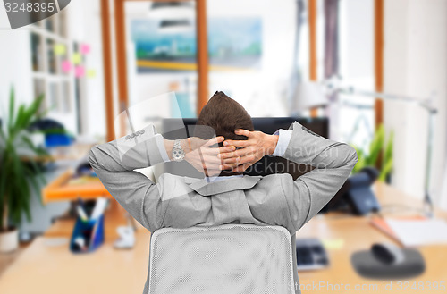 Image of businessman sitting in office chair from back