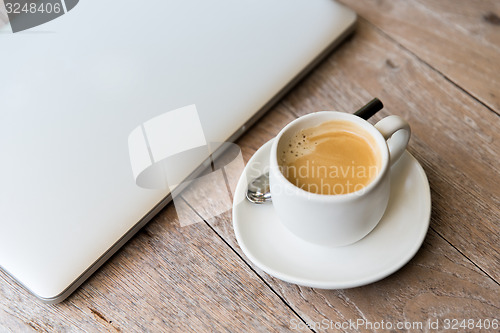 Image of close up of laptop and coffee cup on office table