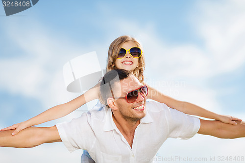Image of happy father and child in sunglasses over blue sky