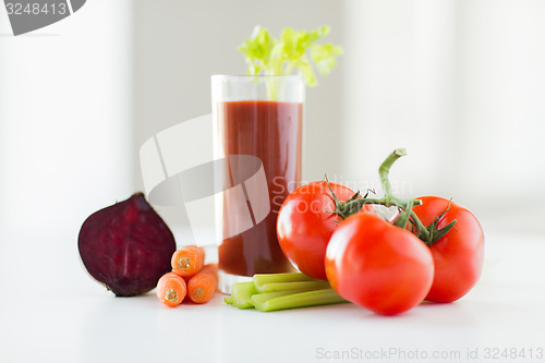 Image of close up of fresh juice and vegetables on table