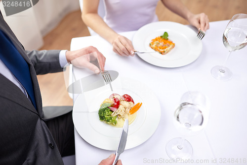 Image of close up of couple eating appetizers at restaurant