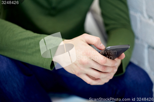Image of close up of male hands with smartphone