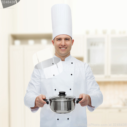 Image of happy male chef cook holding pot