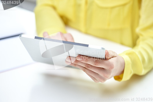 Image of close up of female hands with tablet pc at table