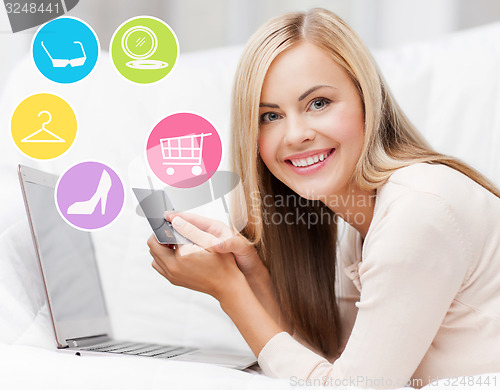 Image of happy woman with laptop and credit card shopping